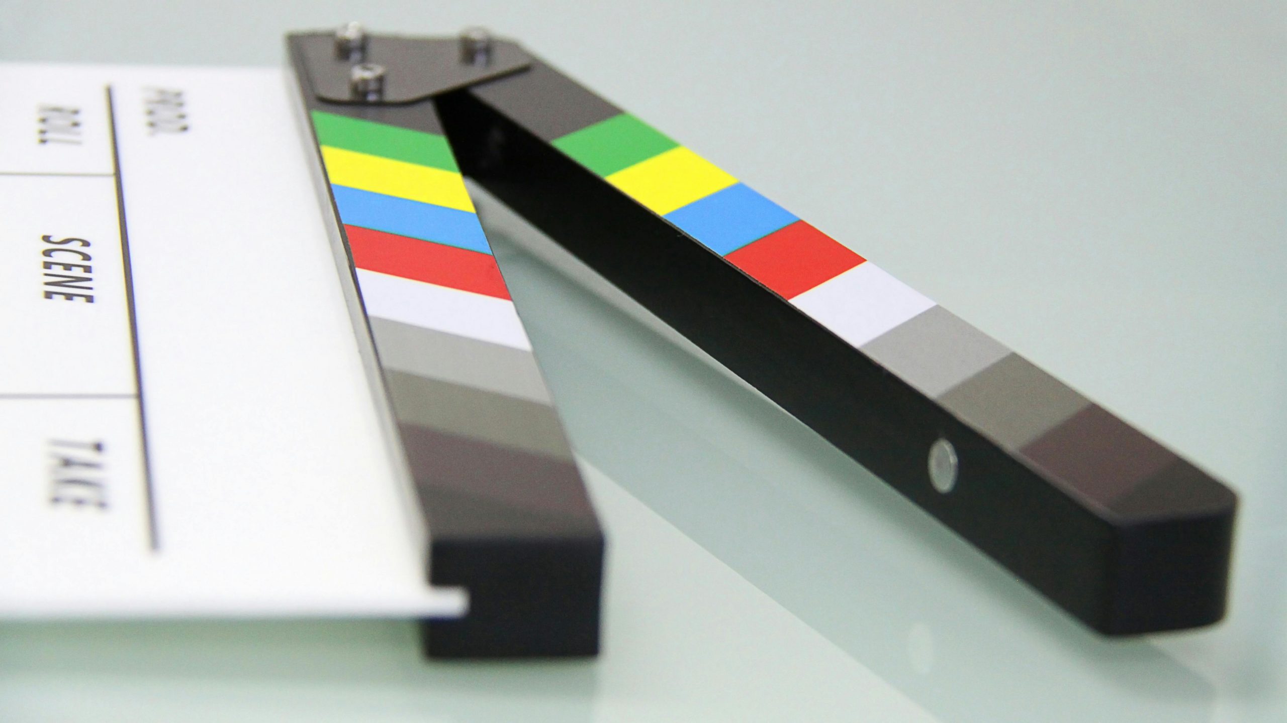 Film clapperboard on a grey table.
