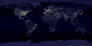 A map of the world at night. We can see twinkly warm tones white lights to indicate which countries are awake.