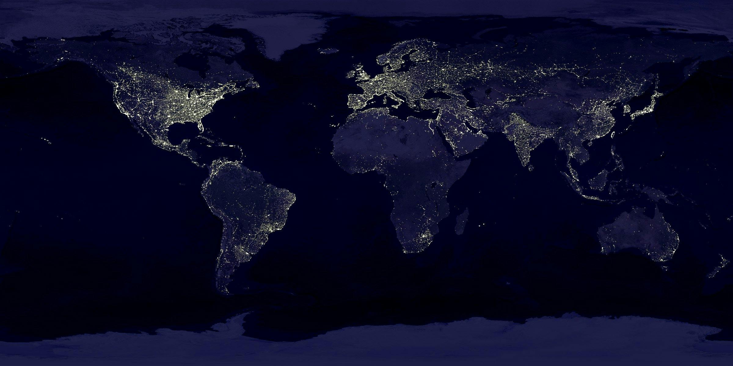 A map of the world at night. We can see twinkly warm tones white lights to indicate which countries are awake.